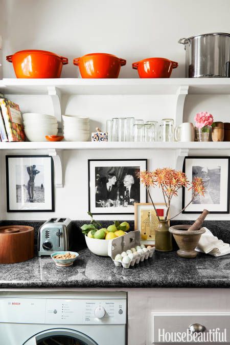 kitchen counter filled with decor objects and black-and-white pictures hanging above the counter