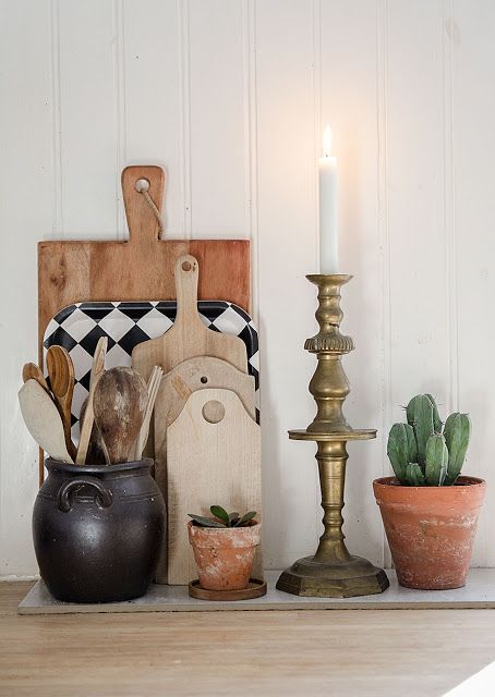 Stacked trays with a brass candle and a succulent next to them