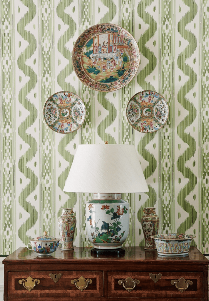 Picture shows a bright green wallpaper with decorative plates to give an idea on how to decor entryway wall