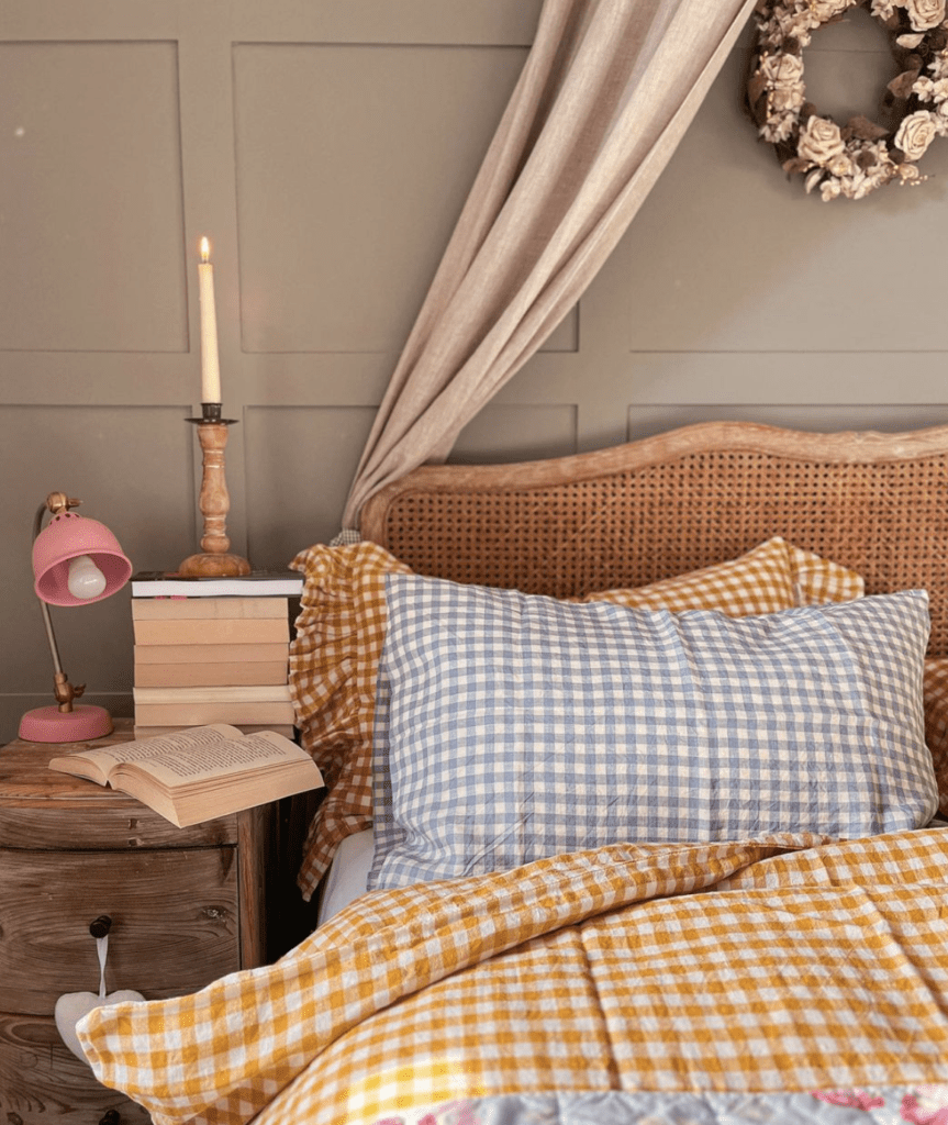 Yellow and light blue gingham bedding on a. bed with rattan frame