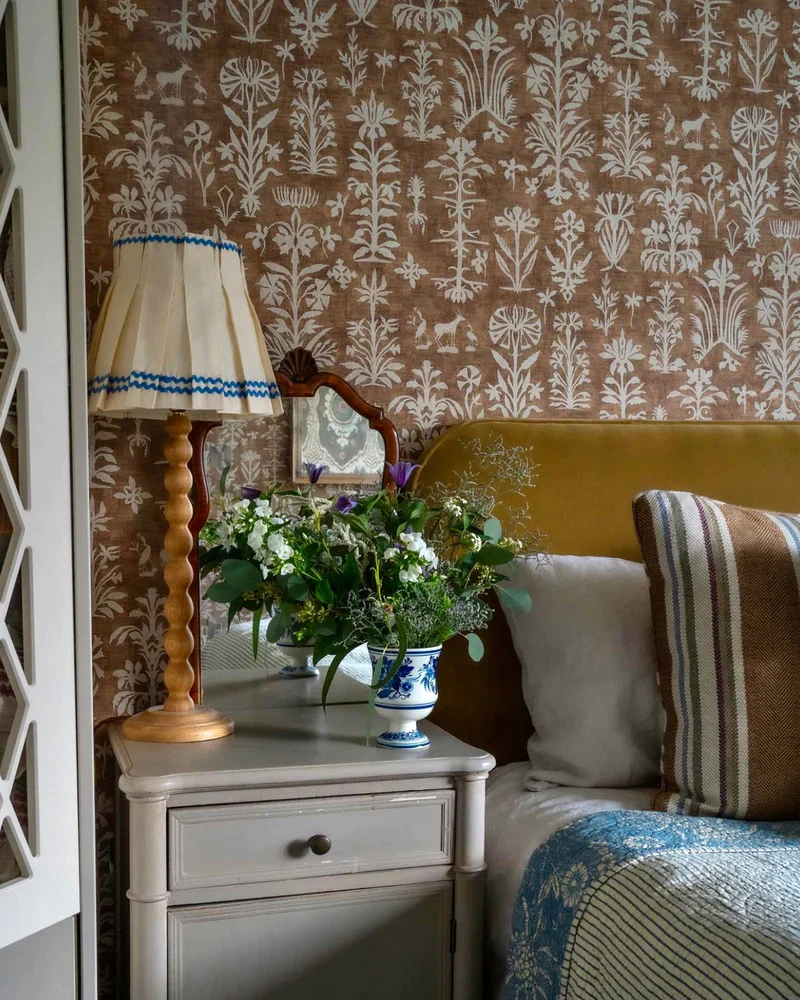 Classic lampshade with wooden decorative base placed on top of a bedside table. 