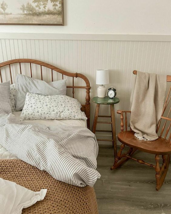 Vintage wood rocking chair with a blanked on it next to a bed styles in cottagecore fashion