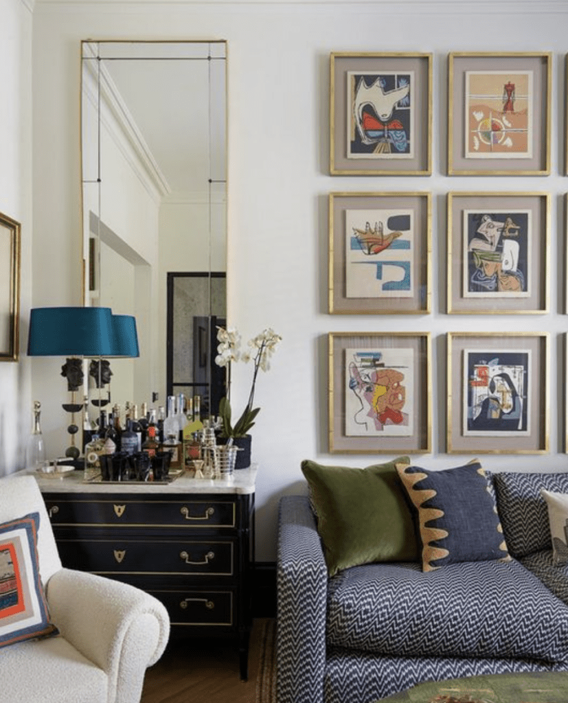 Classic maximalist decor including a gallery wall of nine pieces with similar frames but diverse art pieces