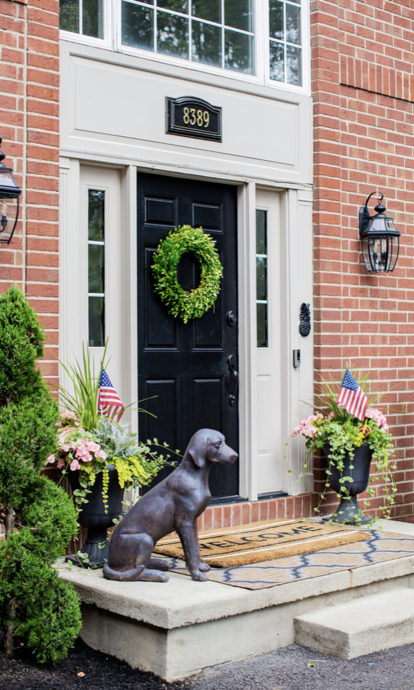 classic front door decor with a concrete statue of hunting dog