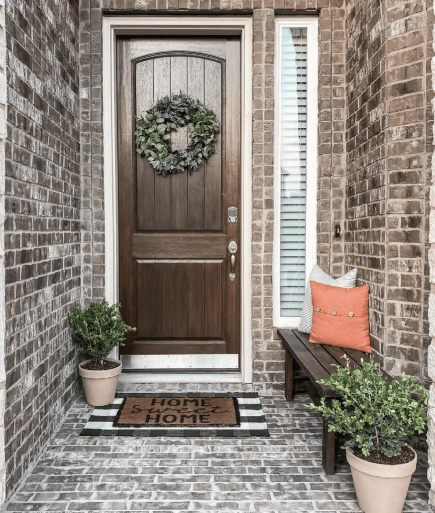 entrance with small wooden side bench and plants 