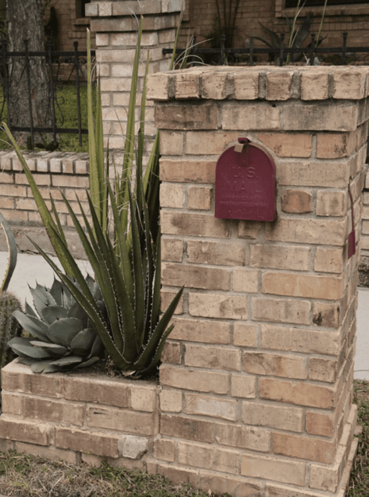 Rustic mailbox landscaping with cactuses and brown brick