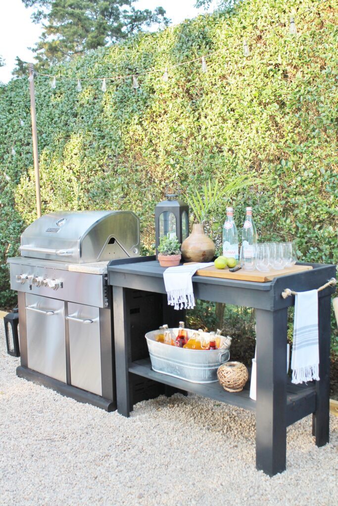 outdoor kitchen with self-standing grill and a wooden side table