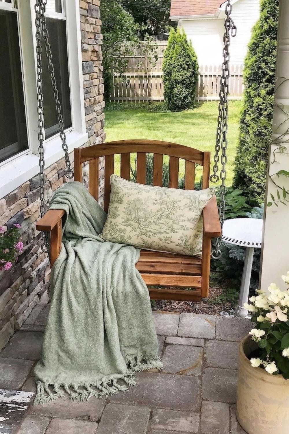 cottagecore style porch with hanging bench and flower vase