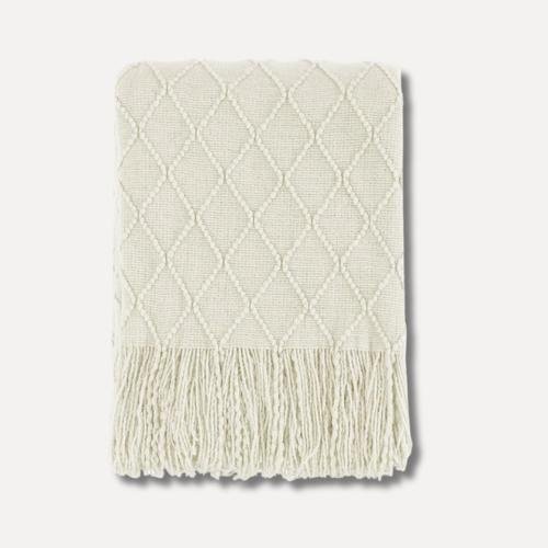 beige knit blanket with fringes that is light and perfect for a chilly summer night